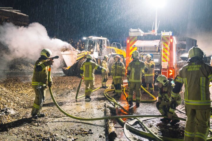 Brennende Holzstämme und Hackgut